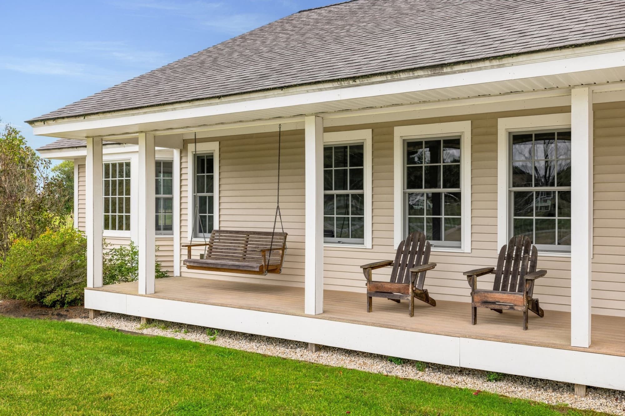 The farmer's porch with a swing and 2 Adirondack chairs